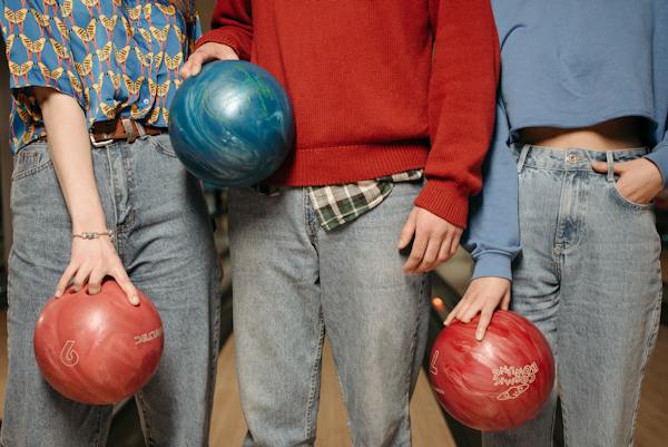 Person in Red Sweater Holding Blue Bowling Ball